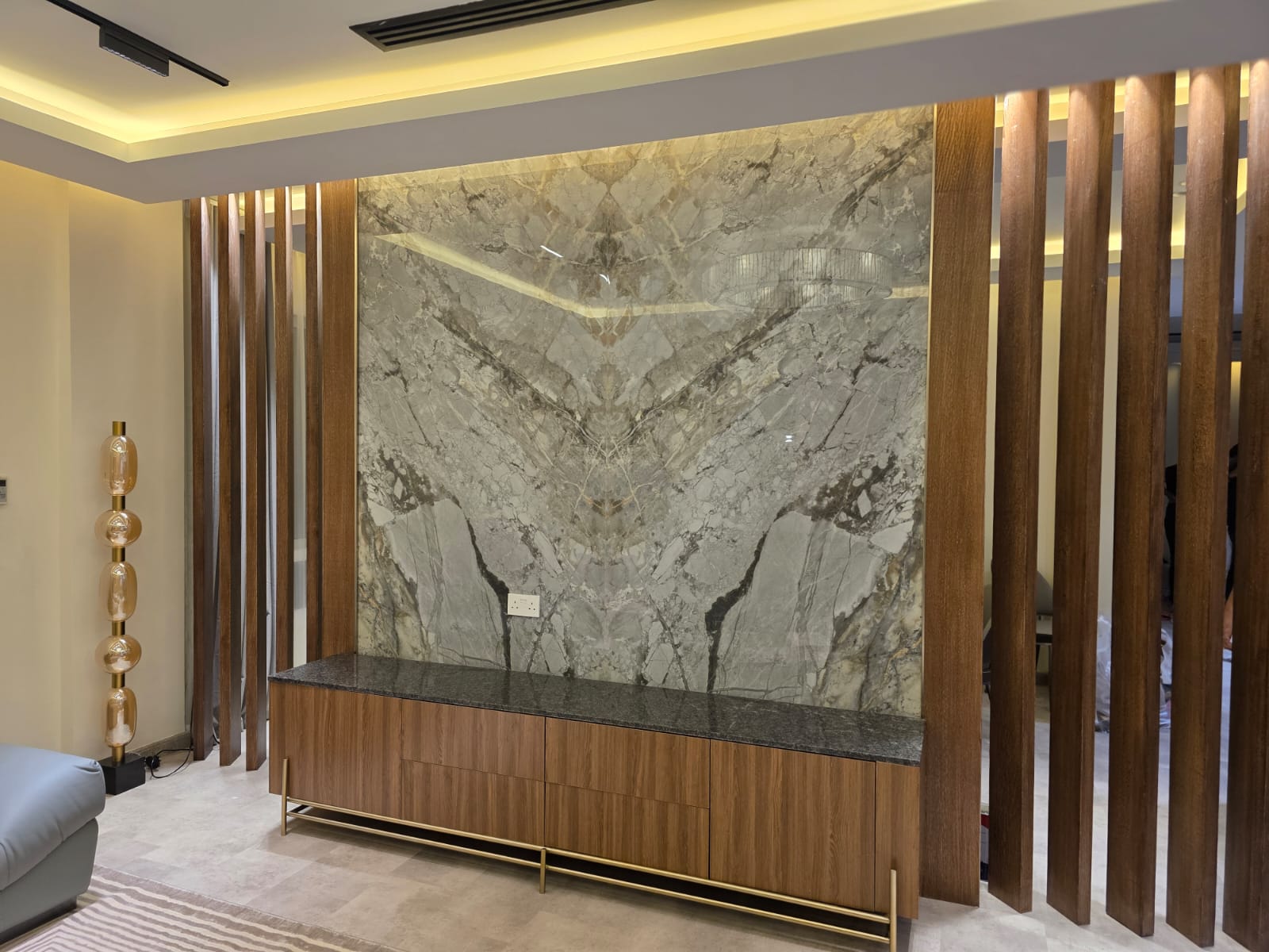Marble feature wall with fluted wood fins and gold-trim media console